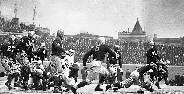 Sammy Baugh, No. 33, of the Washington Redskins, being tackled, far right, during NFL Championship game at Wrigley Field in Chicago on December 12, 1937, in which the Redskins prevailed, 27-21, on stellar play and passing heroics of Sammy Baugh. 