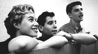 1959, New York: Carole King, Paul Simon, and Gerry Goffin listening to a playback of some music they worked on.