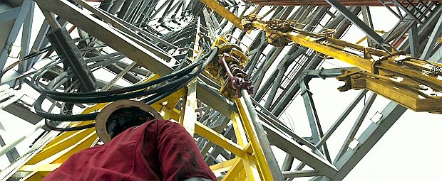 Film clip, drilling rig derrick.  Looking skyward, from the drilling floor of the main deck, up into the farthest reaches of a multi-story, steel-built drilling derrick at the center of the rig.