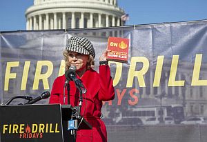 2019. Jane Fonda at “Fire Drill Friday” protest at U.S. Capitol in Washington, D.C., holding up a copy of Naomi Klein’s 2019 book, “On Fire: The (Burning) Case for a Green New Deal.” Click for Klein book. Photo, Tim Aubry/Greenpeace.