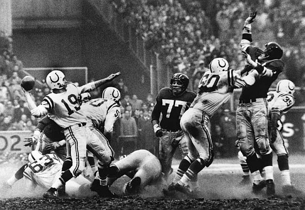 December 28, 1958 game-changer: Famous photo from Baltimore Colts vs. New York Giants  NFL championship game; the game that launched a new era of big time pro football sports culture & big business. Baltimore Colts quarterback, Johnny Unitas, No. 19, shown here about to throw one of his passes.