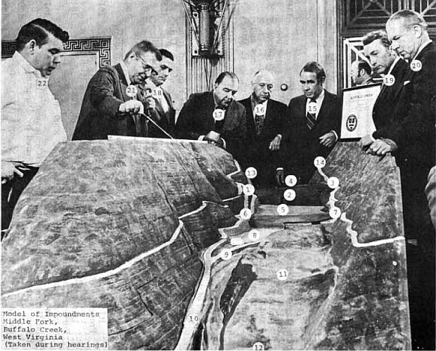 May 1972, Wash., DC.  U.S. Senators and experts gather around scale model of Buffalo Creek area in Senate hearing room showing valley below and three coal waste impoundments (#s 8, 5, & 4) that burst causing catastrophic flood on February 26, 1972. Among officials and Senators shown are, from left: Dennis Gibson, Buffalo Mining Co.(22) Garth Fuguay (21, with pointer), Army Corps of Engineers; Sen. Harold Hughes (18); Sen. Jennings Randolph (17); Sen. Jacob Javits (16); Sen. Harrison Williams (15); Sen. Richard Scheiker (19), and Sen. Robert Stafford (20).