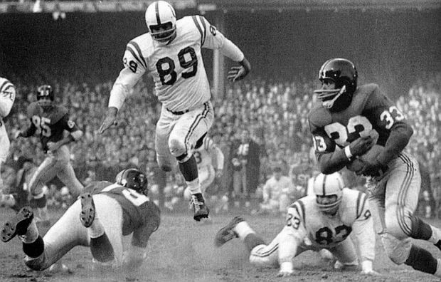 Mel Triplett (33), NY Giants’ fullback, on the move during the 1958 NFL Championship Game, as Colt’s defensive lineman, Gino Marchetti pursues him. Triplett would score Giant touchdown in the 3rd quarter..