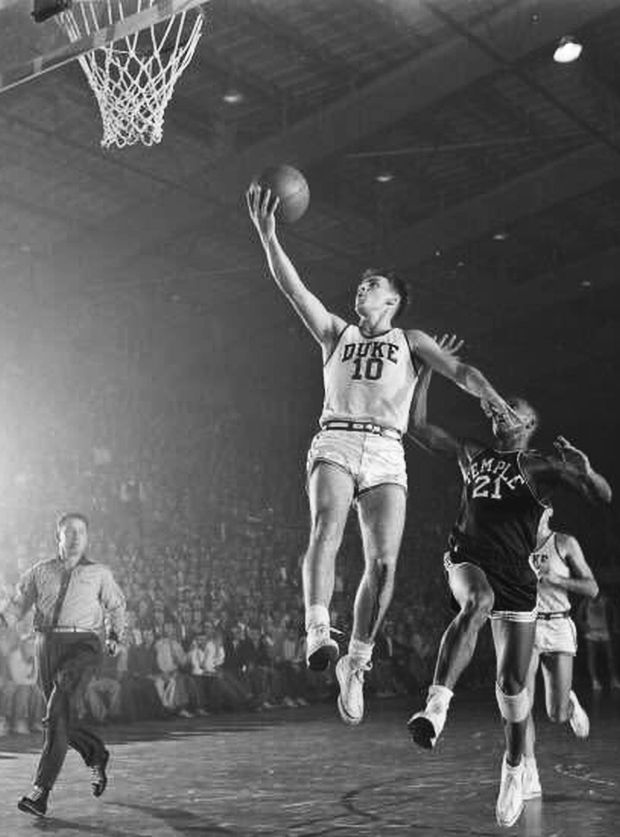 Duke University's hot young guard, Dick Groat (#10), eluding Temple defenders, and taking the ball to the bucket, early 1950s.
