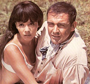 Kissy Suzuki and James Bond cavorting on Japanese hillside as they discover helicopters flying into an extinct volcano.