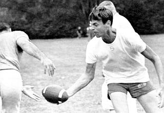 August 1963: George Plimpton, during a light-attire Detroit Lions practice session, is late with hand-off to running back.