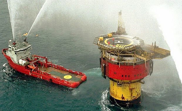 Shell offshore vessel using water canons aimed at Brent Spar to discourage/dislodge Greenpeace activists on the structure. This is a later, mid-June 1995 photo, after two Greenpeace activists had re-boarded the Brent Spar via helicopter. AP photo.