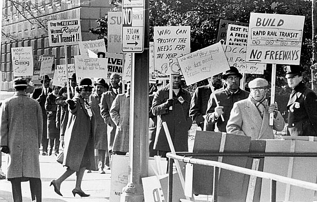 February 1965. Sammie Abbott (at far right near policeman), with contingent of citizens demonstrating against freeways, but supporting rapid transit for DC Metro region. Photo by Walter Oates / DC Public Library, Star Collection, Washington Post.