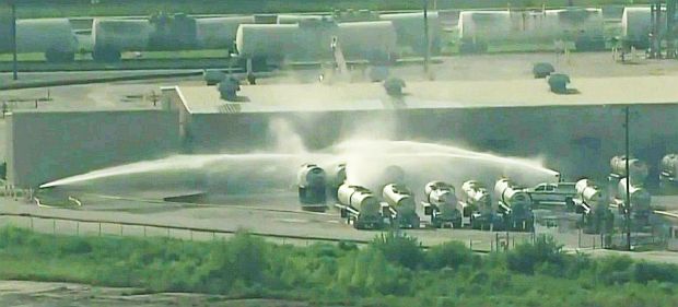 News photo from July 21, 2021, showing tank truck area at Dow Chemical’s LaPorte, TX chemical works and tanker units being sprayed with water, as one was leaking at the time, with fears of possible fire and/or explosion.