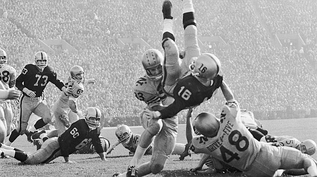 Army’s QB, Rollie Stichweh, was upended by Navy defenders Ed Orr and Johnny Sai, right, while scoring a first-quarter touchdown.