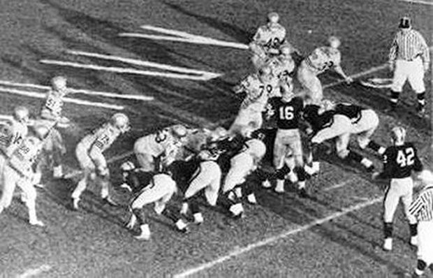 With less than 20 seconds remaining in the 1963 Army-Navy game, Army’s QB, Rollie Stichweh (No. 16) and team line up on the 2 yard-line, but with crowd noise and no help from officials, the Cadets are having difficulty hearing the signals, and they can’t get off another play. 