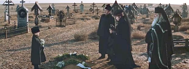 Young Yuri Zhivago, with flowers at left, at the grave site of his mother as services are performed.